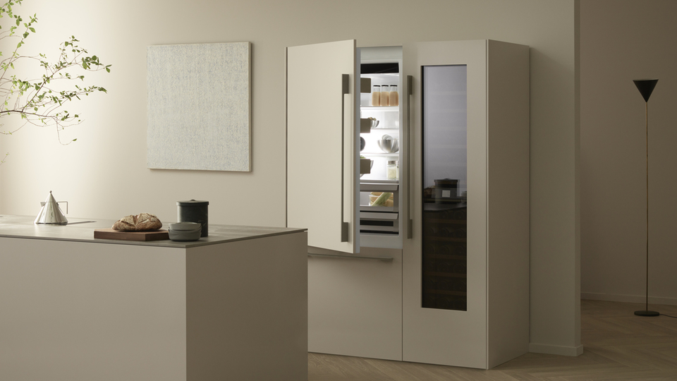 Open fridge and wine cabinet in modern kitchen with minimalist furnishings.