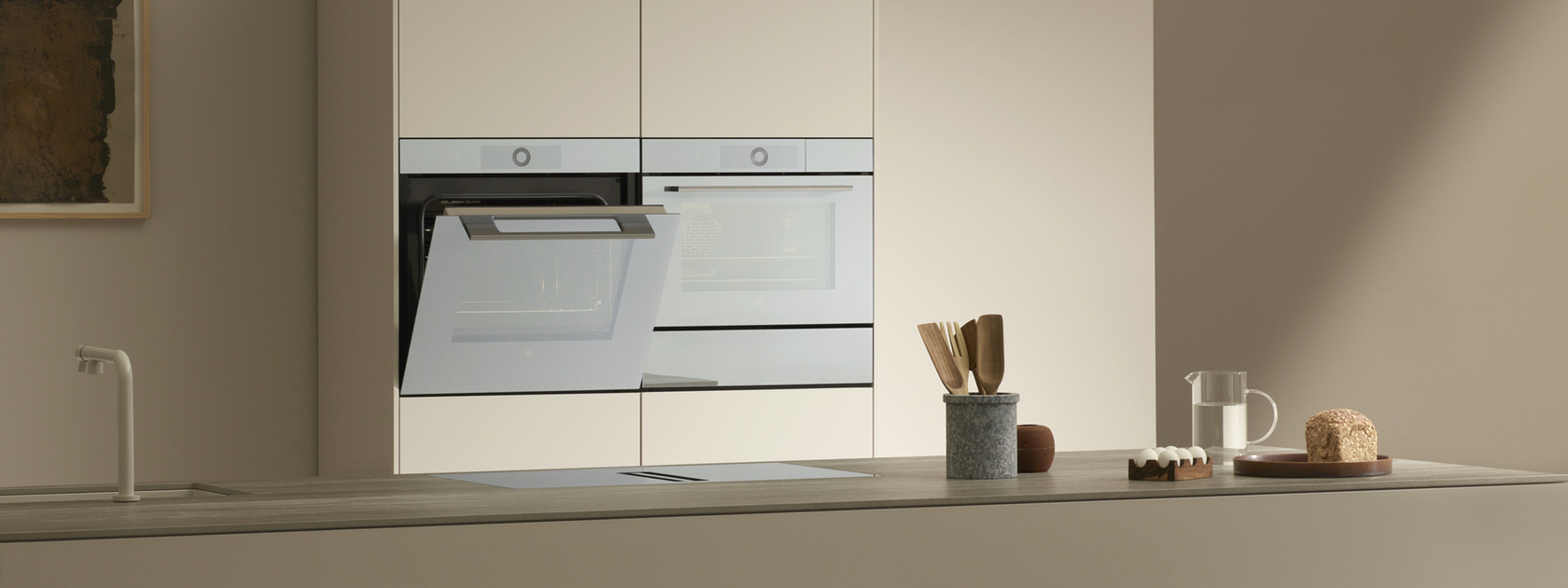 Modern kitchen with two built-in ovens and minimalist furnishings.