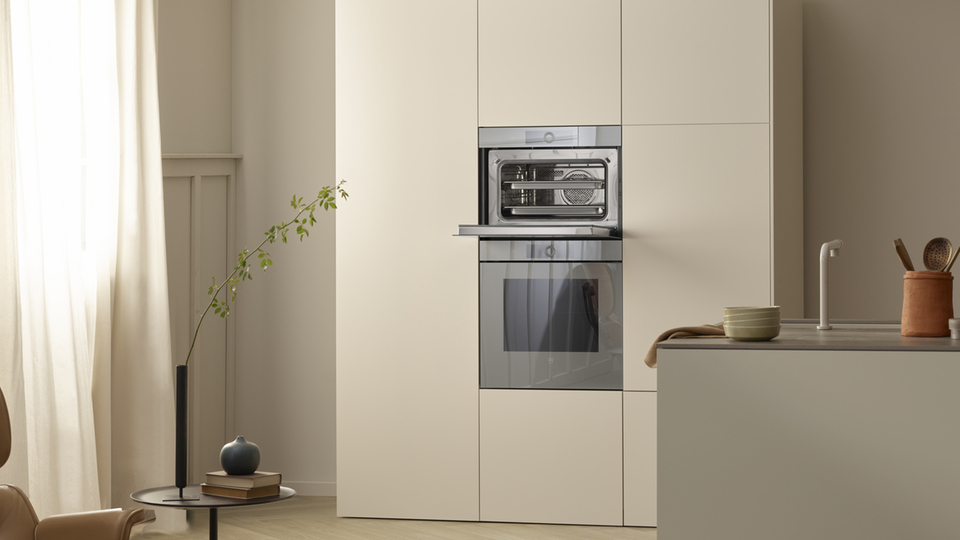 Minimalistische Küche mit eingebautem Backofen und modernen Designelementen.