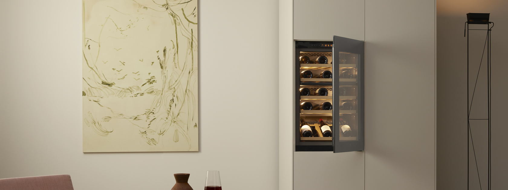 Wine cabinet with open door in a modern living room with artwork and minimalist design.