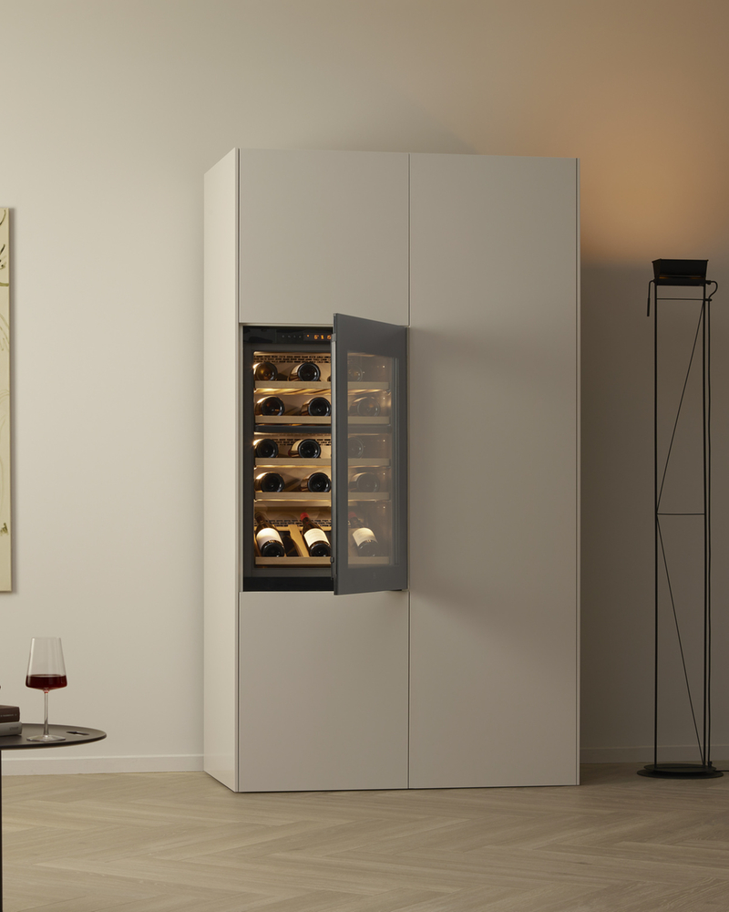 Wine cabinet with open door in a modern living room with artwork and minimalist design.