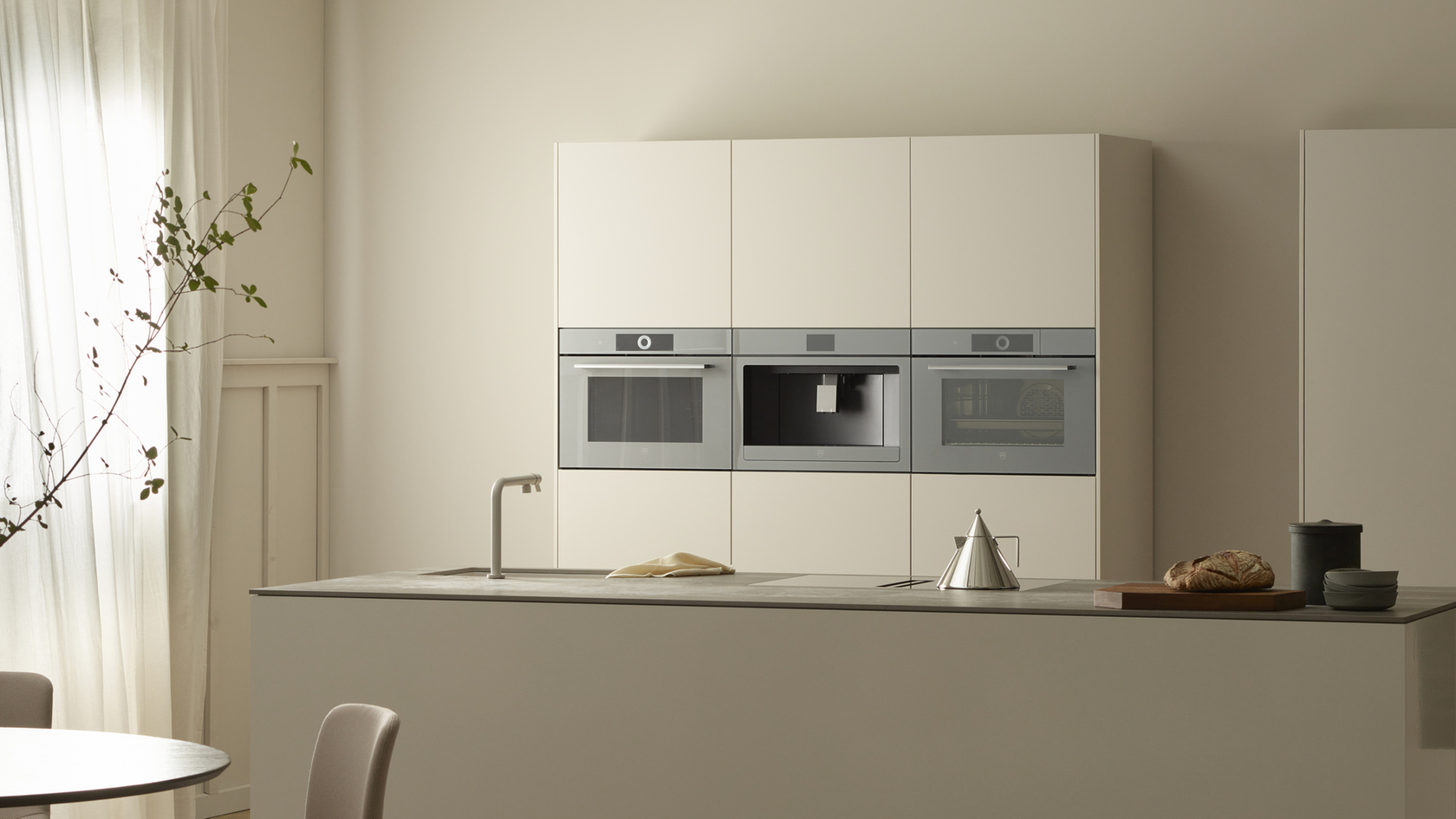 Modern kitchen with built-in ovens, steamer and coffee machine in a minimalist design.