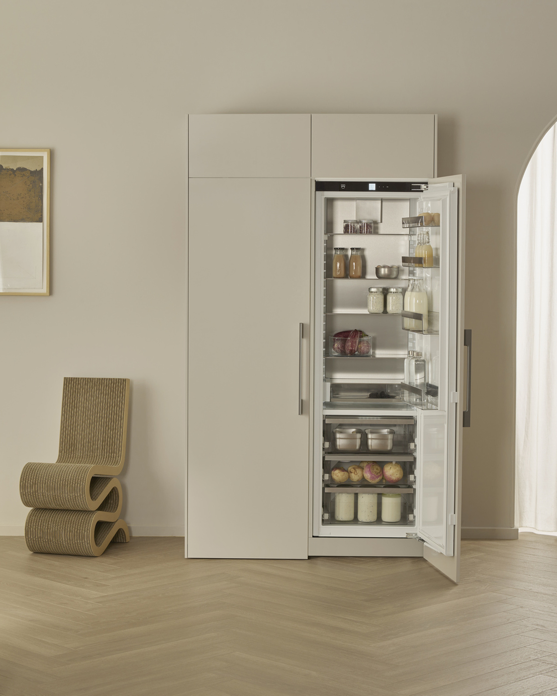 Modern refrigerator with open door in an elegant kitchen, filled with various foodstuffs.