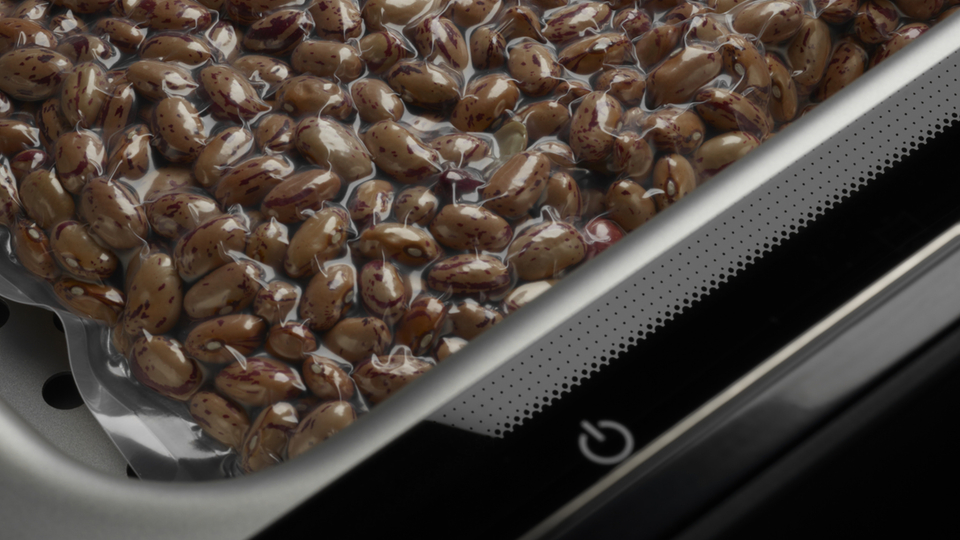 Vacuum-packed beans in a kitchen appliance, close-up to show the freshness and vacuuming technology.