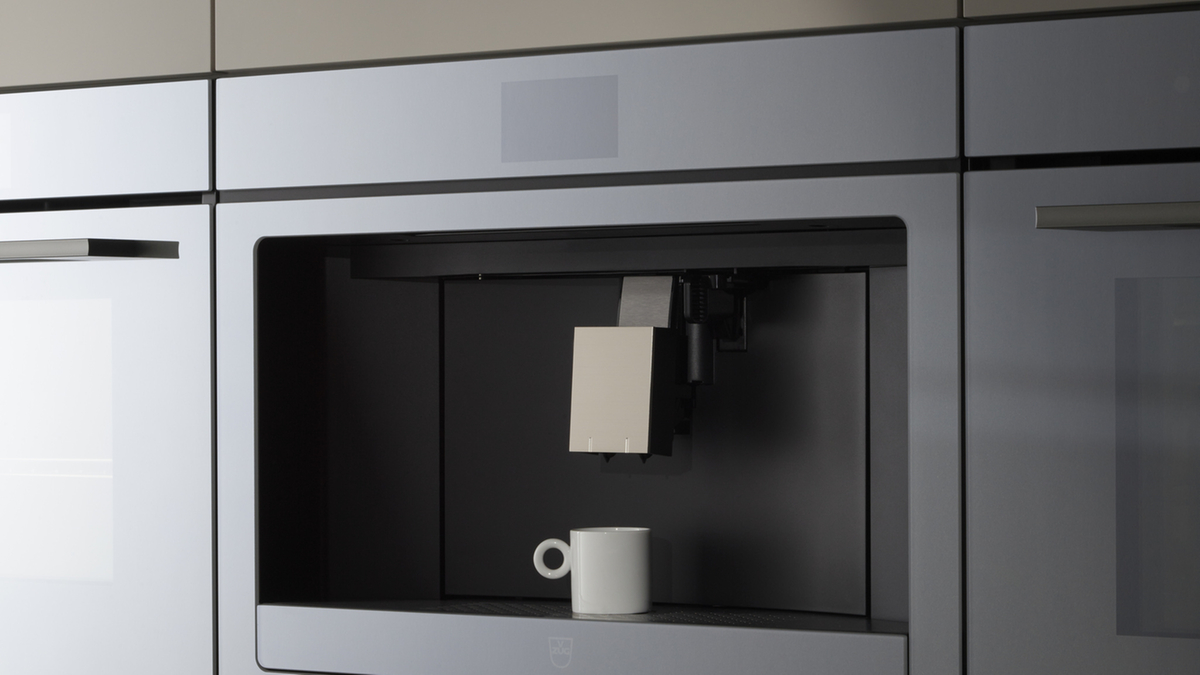 Macchina da caffè da incasso in una cucina moderna con accenti di design minimalista.